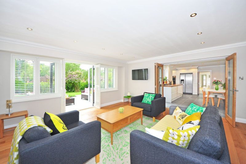 Modern living room with open plan kitchen and garden view, bright and airy ambiance